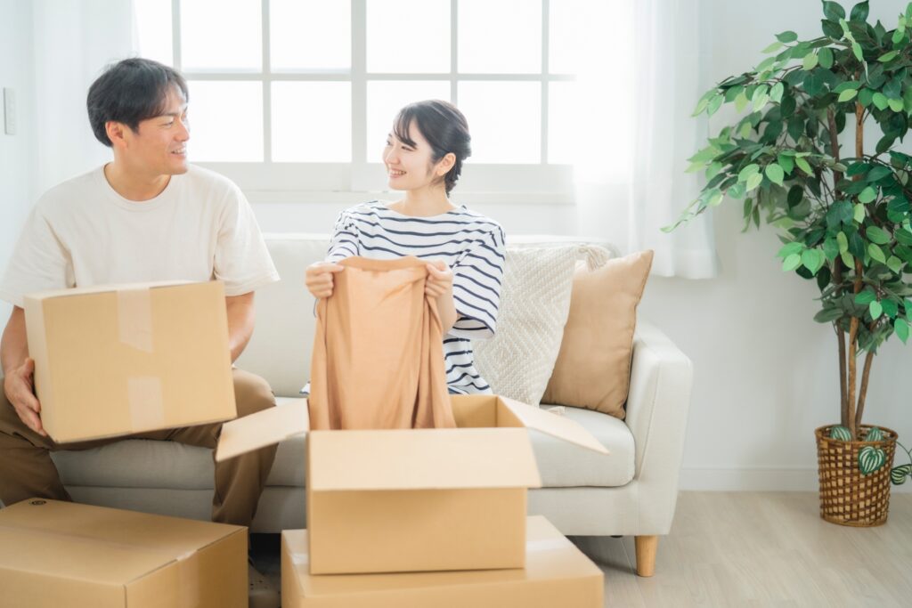 ダンボールの中の洋服を持つ男女