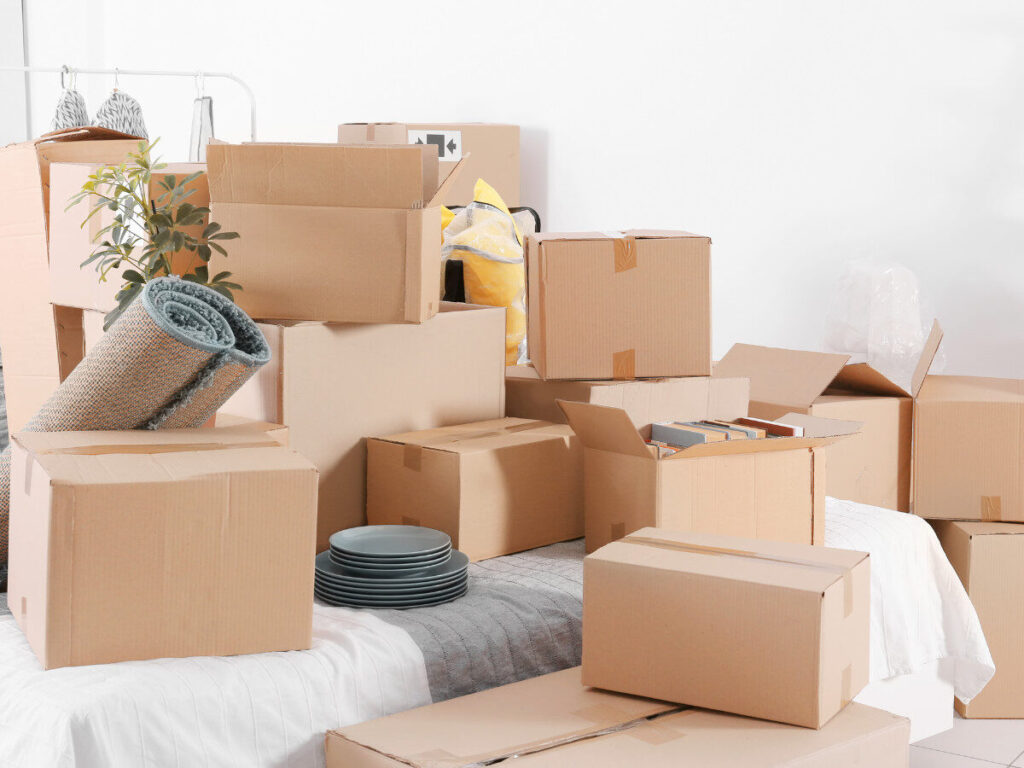 部屋いっぱいに積まれた引っ越し荷物と段ボール