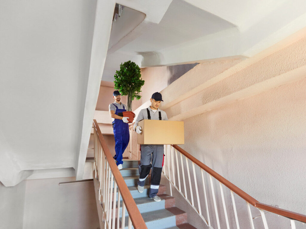 引っ越し業者が階段で荷物を搬出している様子