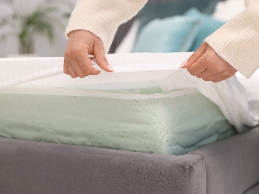 ベッドマットレスにカバーをかける手元のアップ