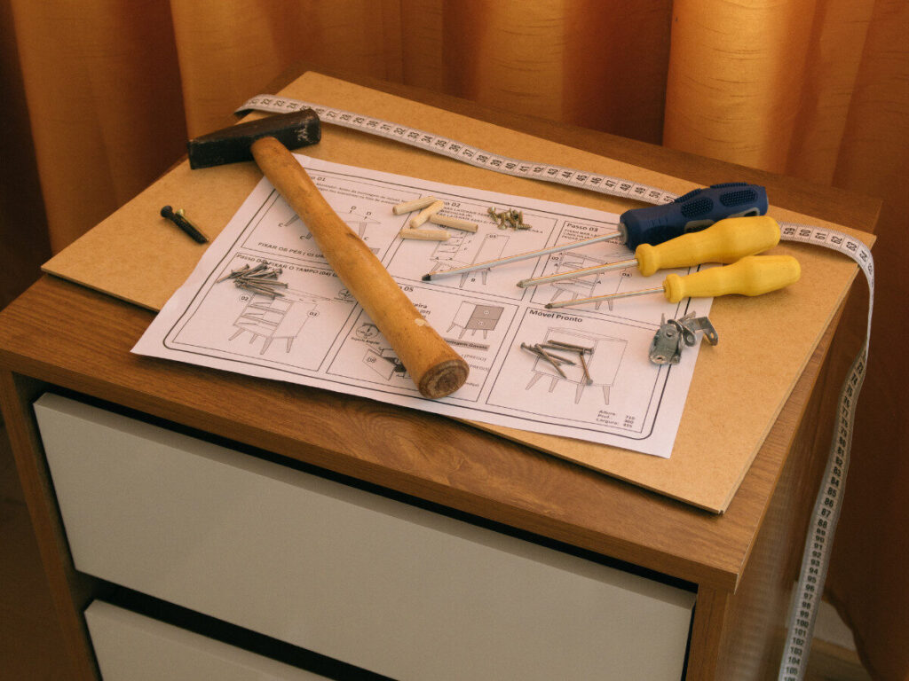 家具の組立用説明書とネジ・ドライバーが並ぶDIY作業風景