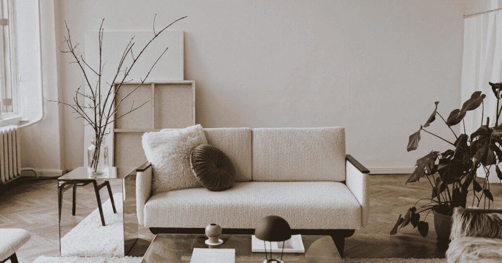 明るい日差しが差し込む北欧風リビングとベージュのソファ