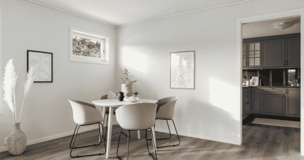 白を基調とした北欧ダイニングと奥に見えるシックなキッチン